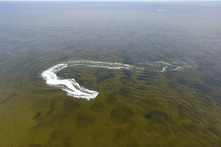 a man flying through the air while riding a wave in the ocean